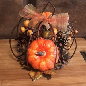 Iron pumpkin filled with harvest decor.